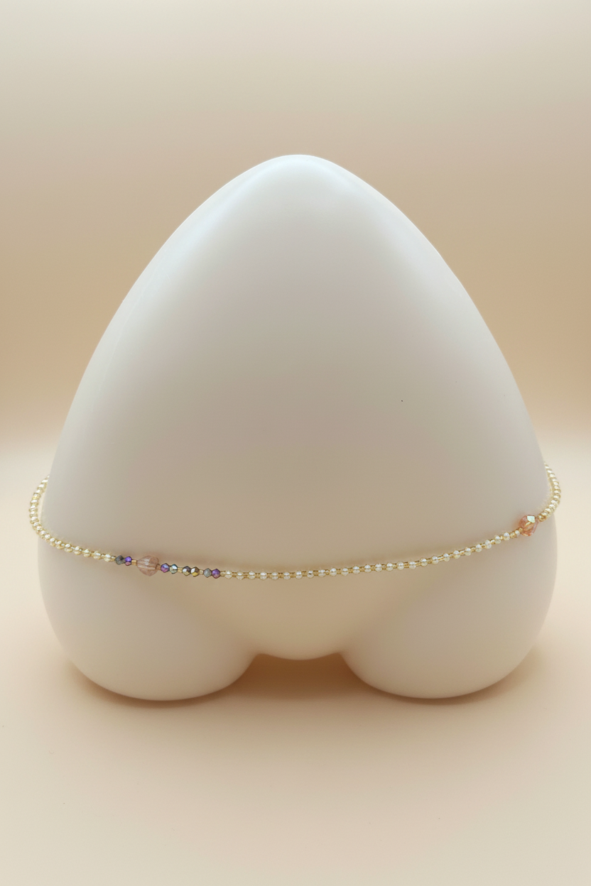 Handmade delicate waist beads on cream background