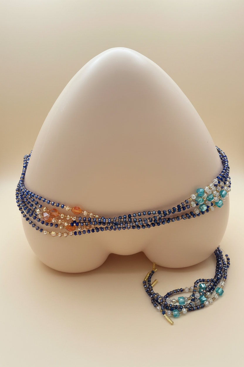 Layered blue and gold waist beads on cream background