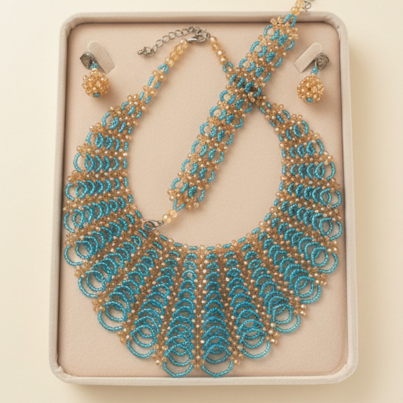 Handmade turquoise and gold beaded necklace set in jewellery box on cream background