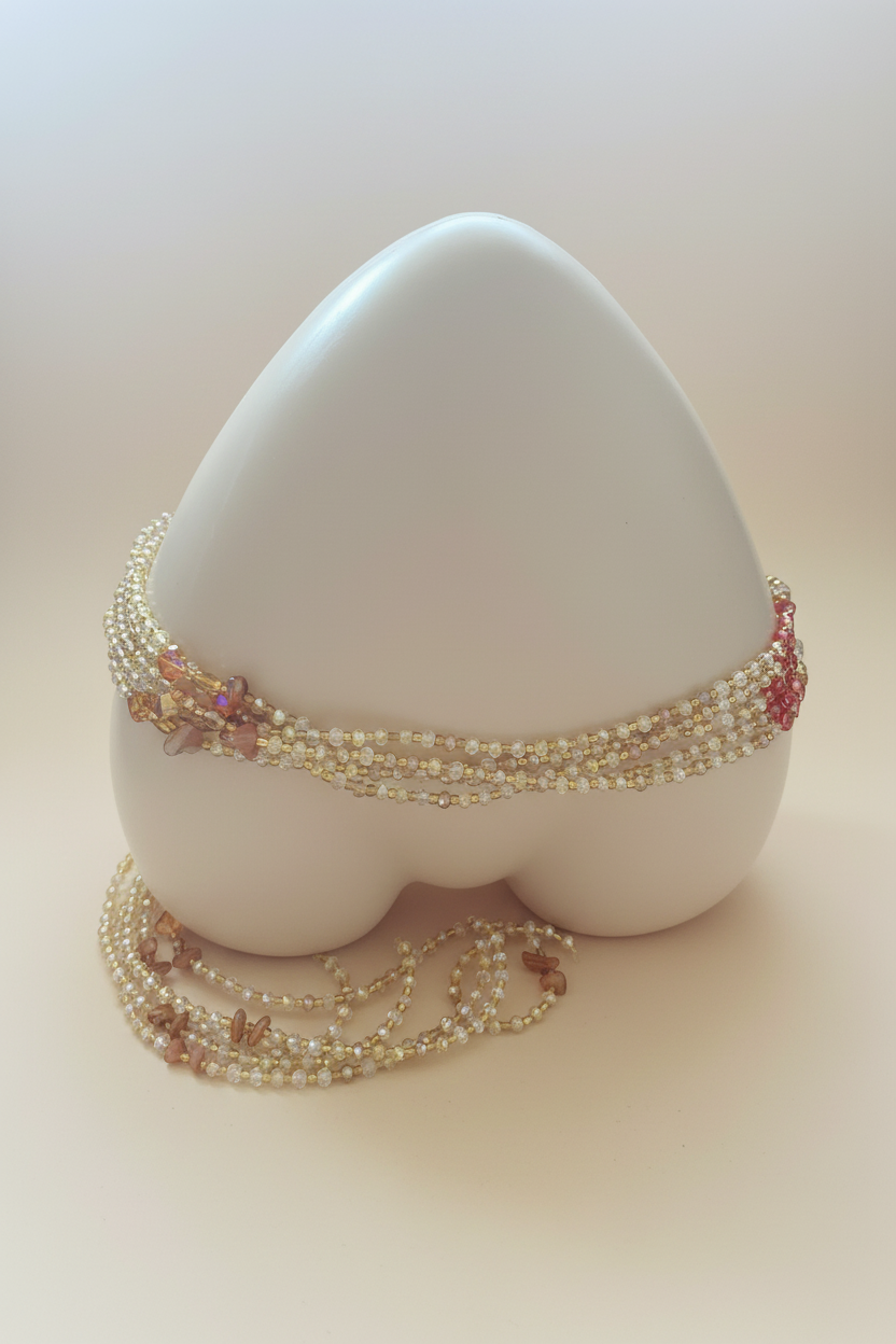Handmade gold crystal waist beads on cream background