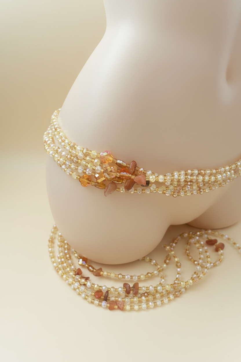Handmade gold crystal waist beads close up on cream background